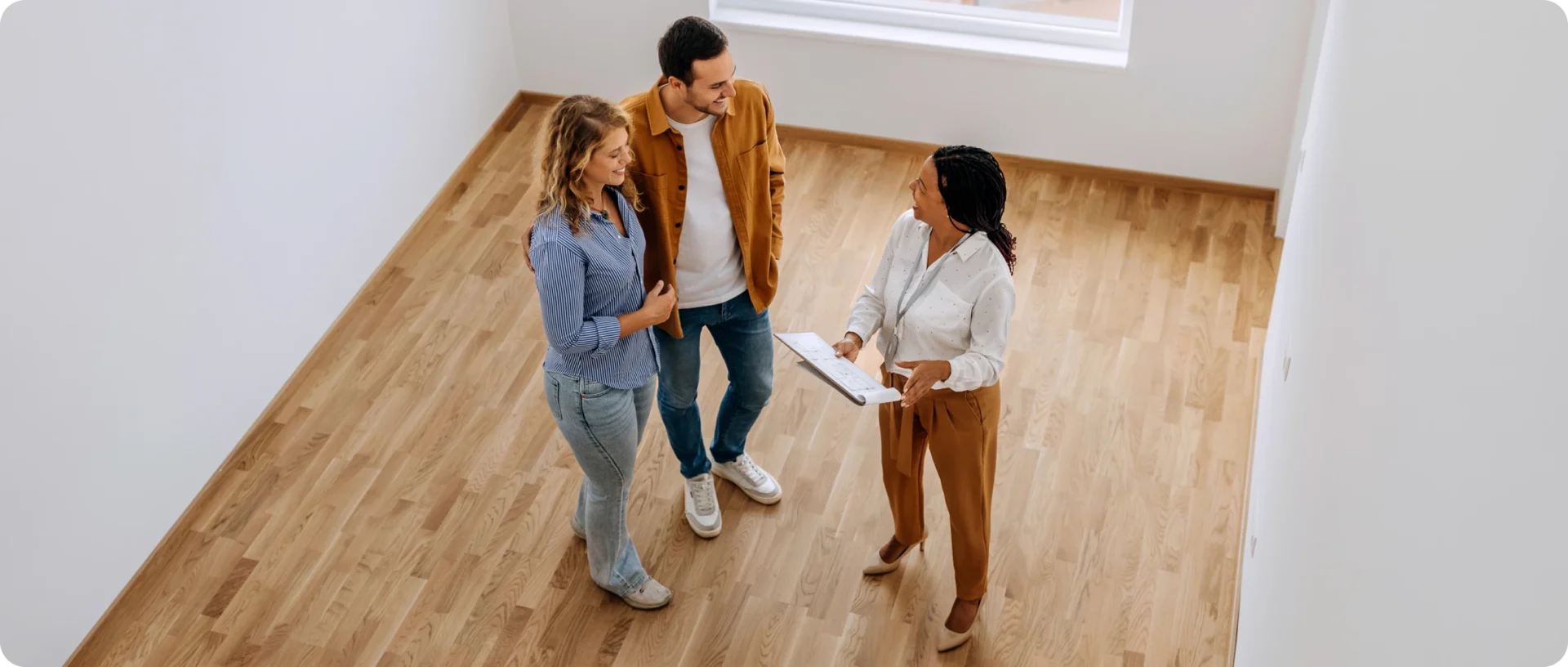 Couple viewing empty room with realtor
