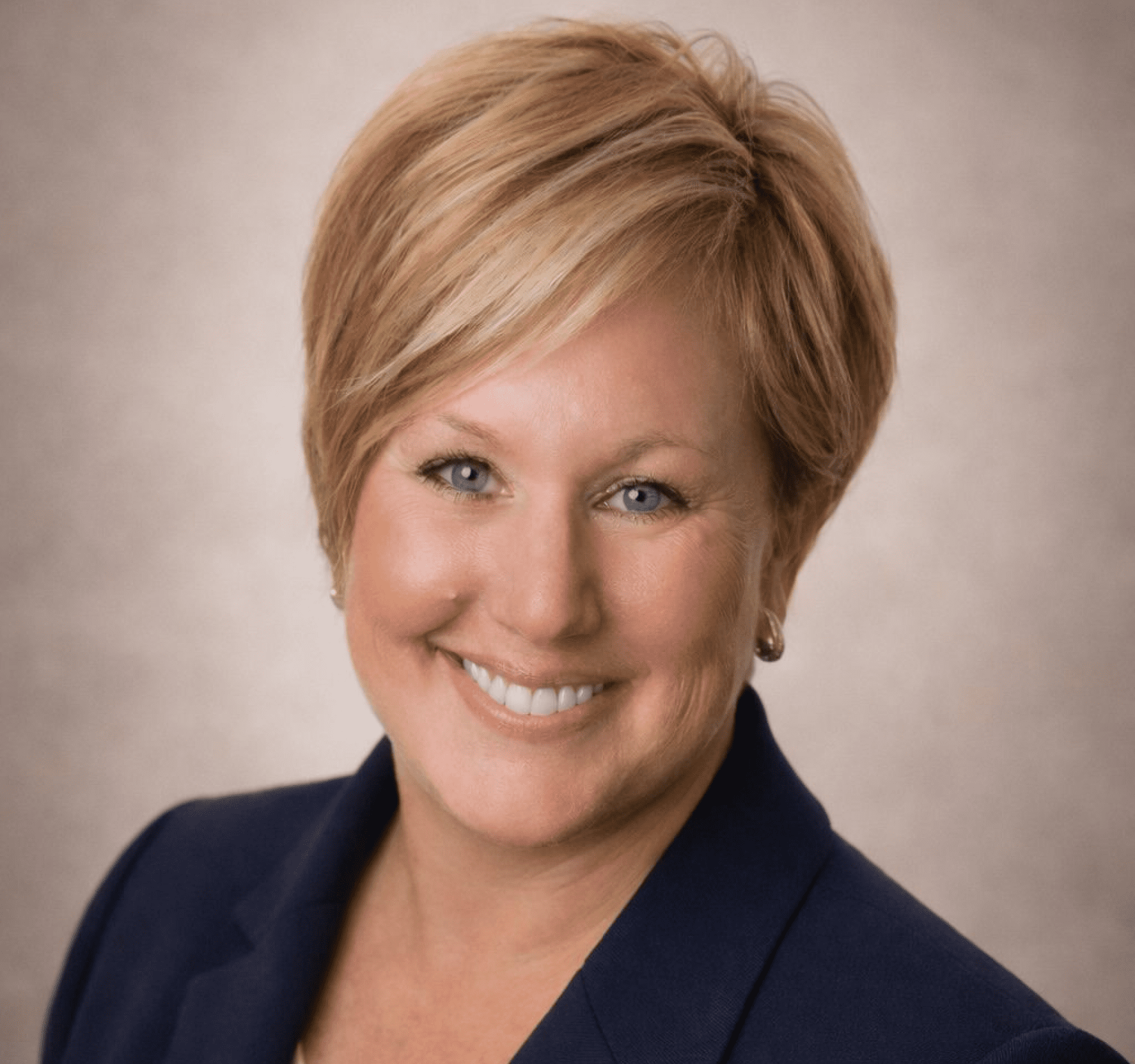Professional headshot of a smiling woman in a blazer.