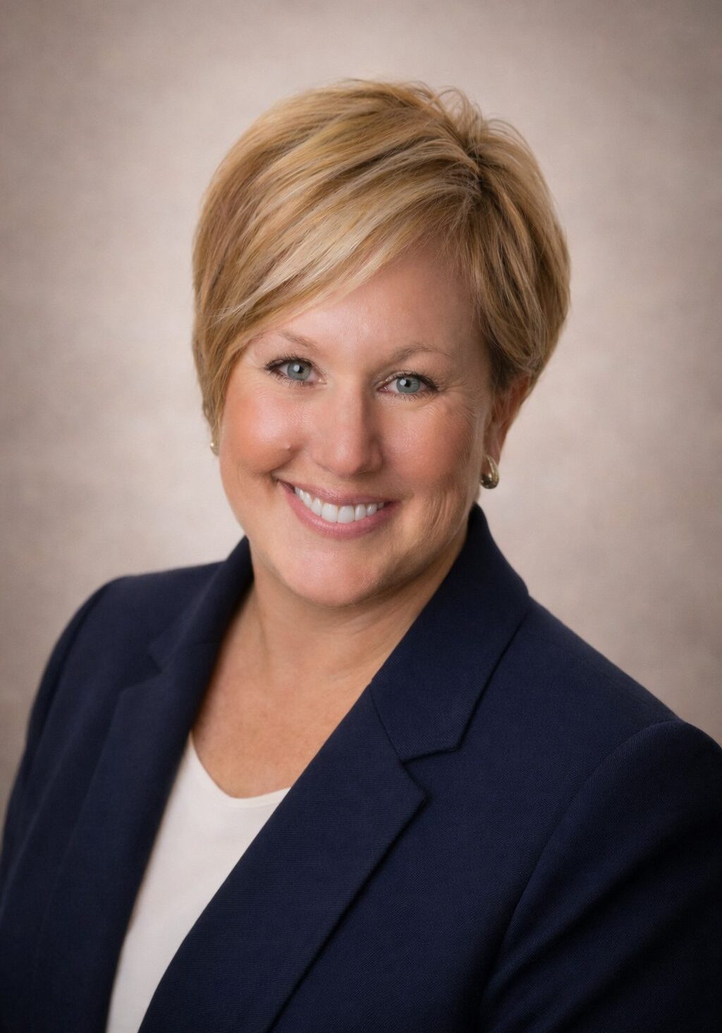 Professional woman with short blonde hair in business attire.