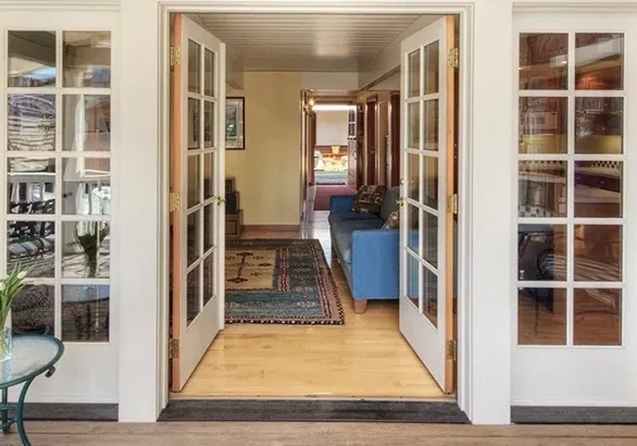 Open French doors leading to cozy interior